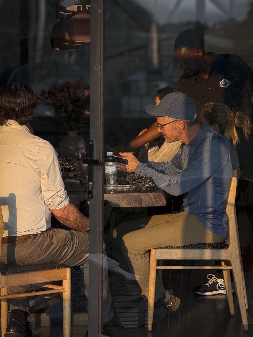 Guests dining at Kinigi Table at golden hour